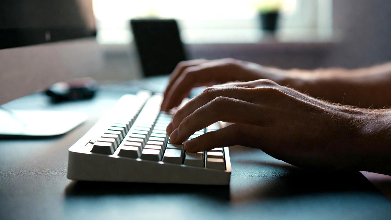 分割キーボードを中心に整えられたデスクで集中して作業するITエンジニアの作業環境