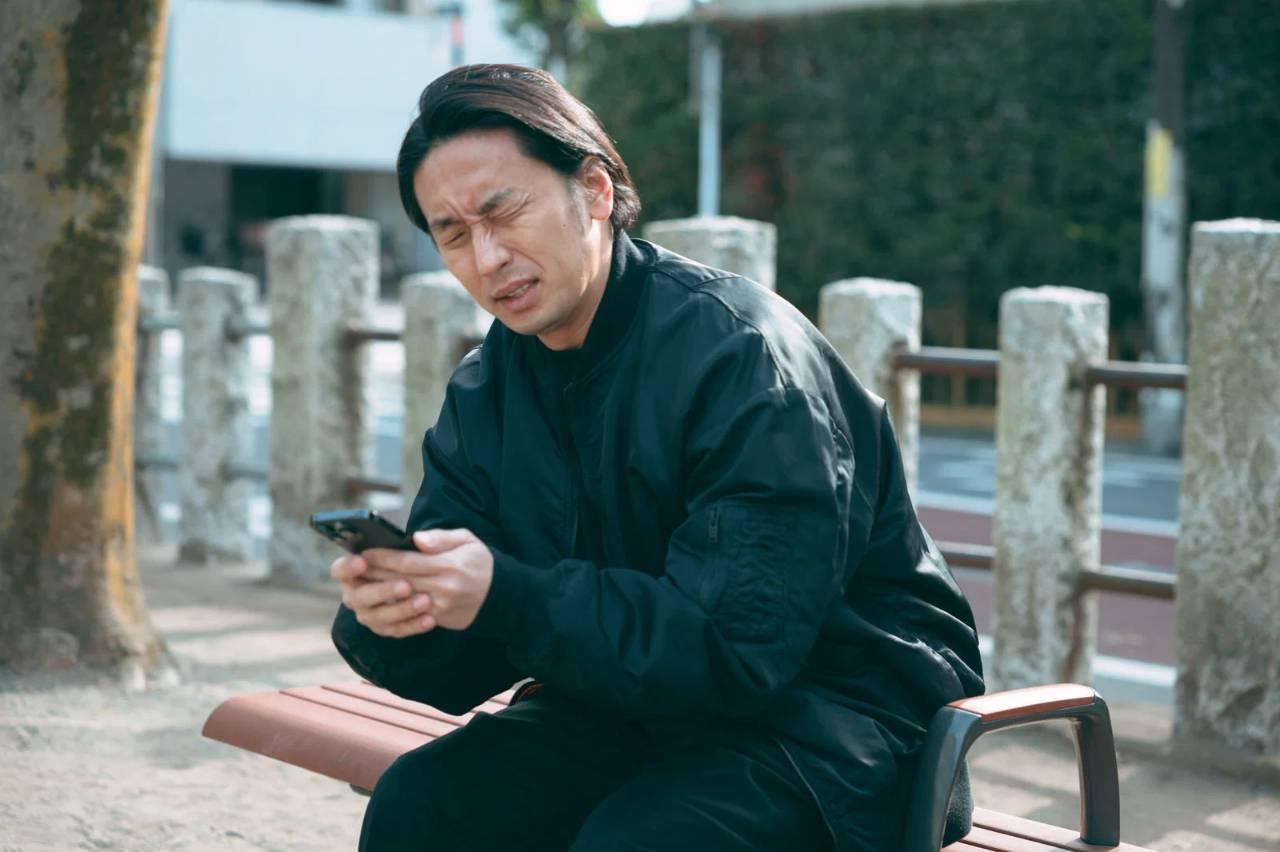 朝日の中でスマートウォッチを確認する人のシルエット。新しい一日の始まりをイメージ