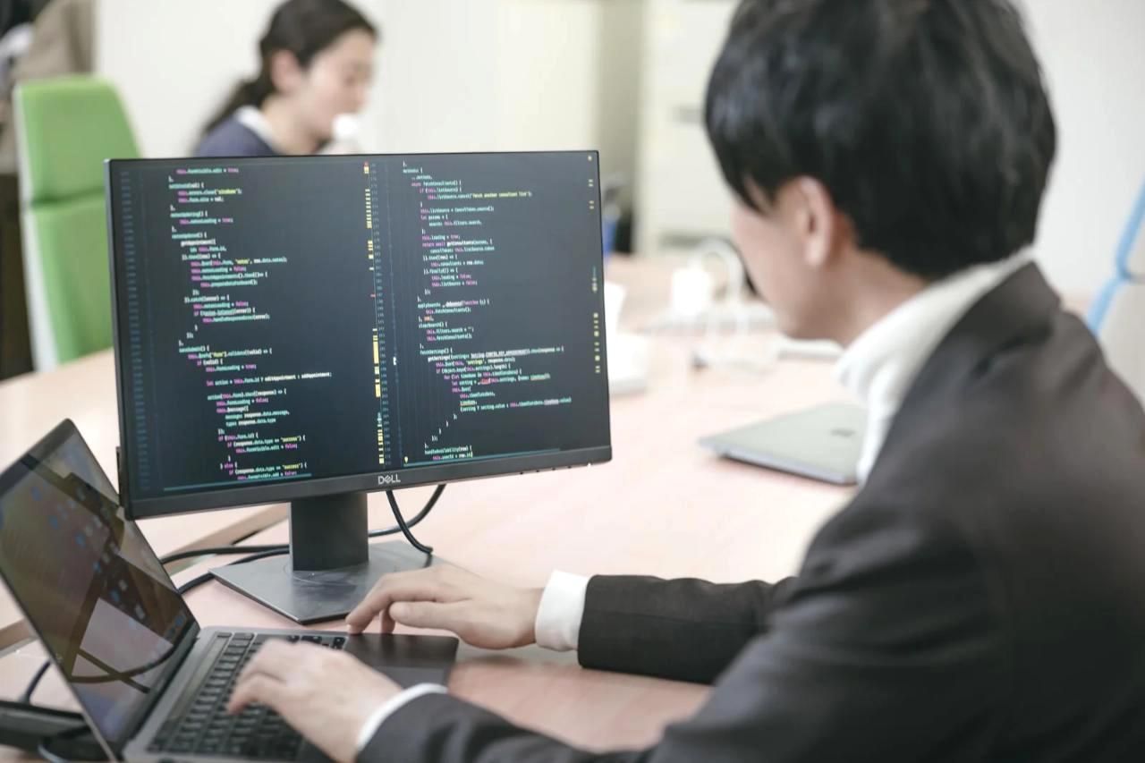 カフェでノートパソコンだけを使って作業するノマドワーカーの背面姿
