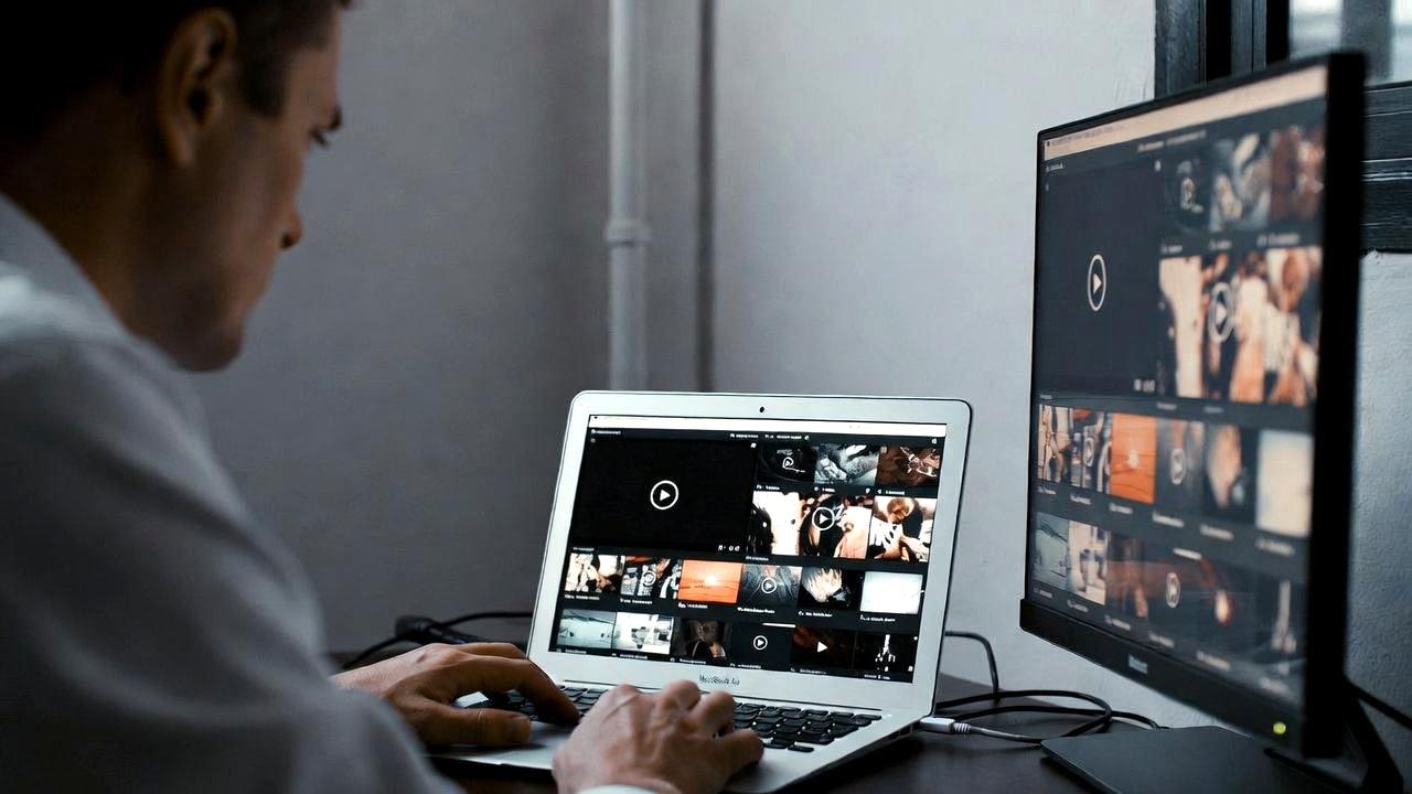 ノートPCとモバイルモニターをカフェで使っているが、荷物が多くて疲れている人の写真