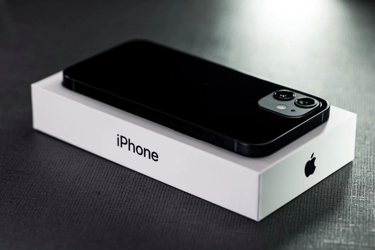 マイクロファイバークロスでiPhone画面を一方向に拭いているクローズアップ写真