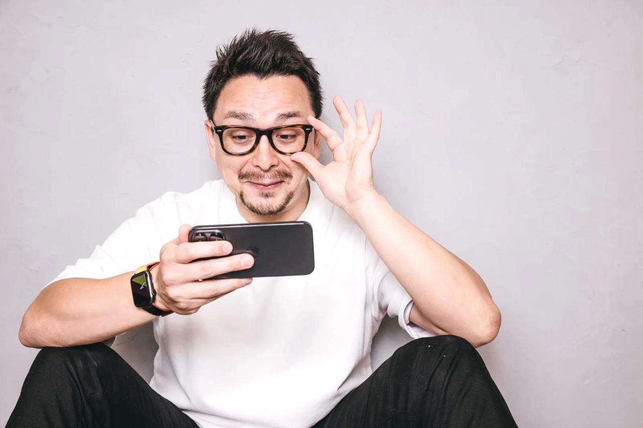 スマートフォンの電源ボタンと充電中のバッテリー表示をクローズアップした写真
