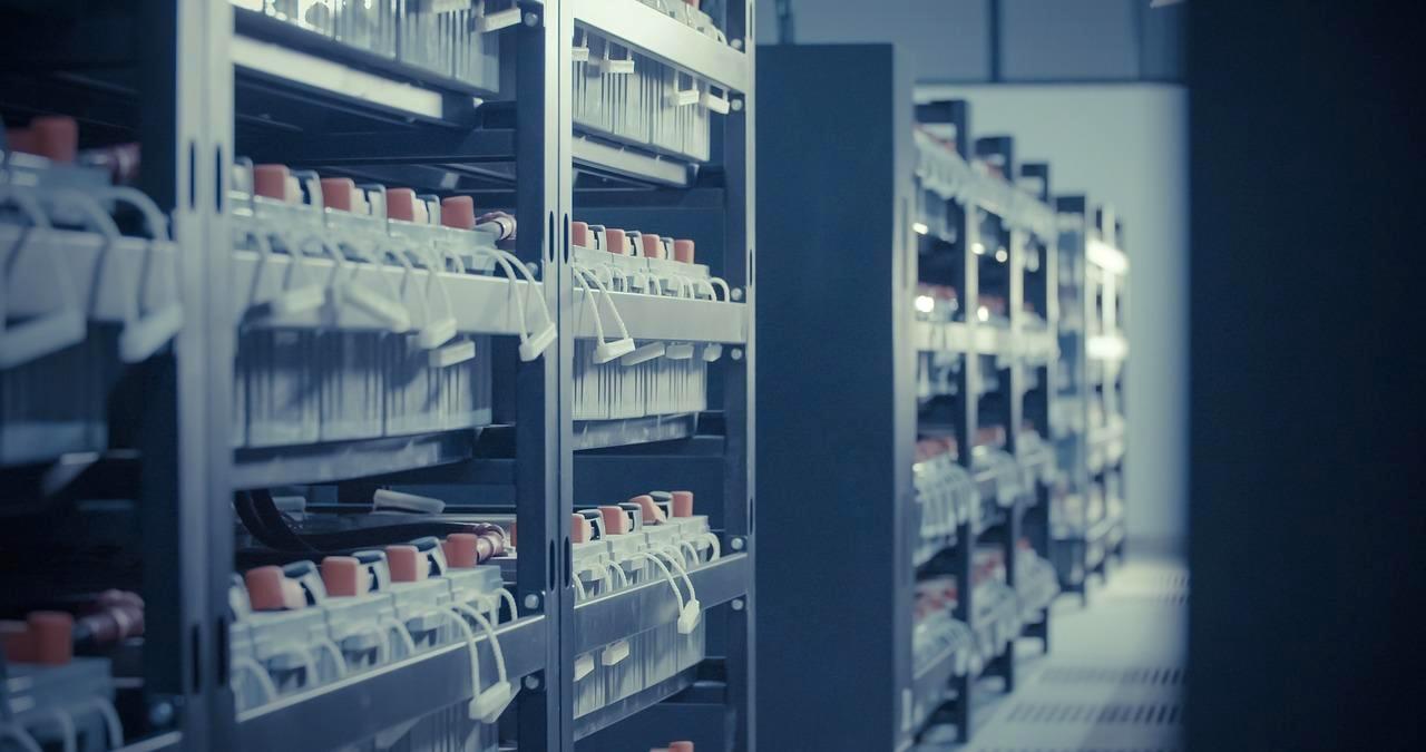 NAS筐体とサーバーラックの写真に、NTFSとBtrfsのロゴが重ねられたイメージ